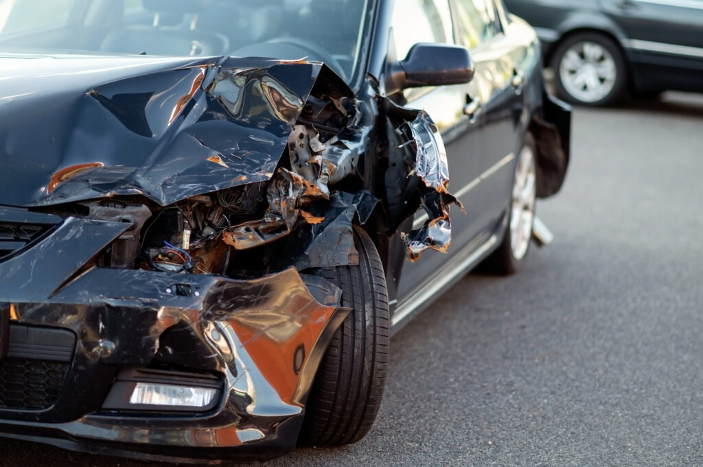 close up of damaged car part after accident showing broken metal and scratches.