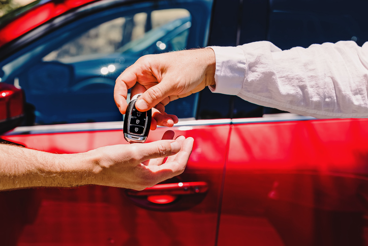 Dealer handing over car keys to driver -what happens after an accident with a dealership loaner car?
