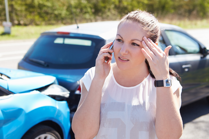 woman on the phone after a car accident - Can you get deported for a car accident?